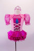 Pink and fuchsia dress has pink glitter velvet bodice with faux corset front and teardrop, pouffe organza fuchsia sleeves and ruffled sateen skirt. The keyhole back has a large white bow at the mid center of the back. Comes with a tiara hair accessory. Front