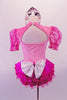 Pink and fuchsia dress has pink glitter velvet bodice with faux corset front and teardrop, pouffe organza fuchsia sleeves and ruffled sateen skirt. The keyhole back has a large white bow at the mid center of the back. Comes with a tiara hair accessory. Back