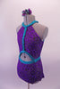 Purple and pewter leotard has an intricate swirl design throughout. The costume has a halter neck with an oval opening at the front center & completely open back. The bright splash of turquoise is evident in the braided banding that accents the front torso, collar, waist & neck straps. Comes with a floral accessory. Side