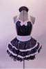 Waitress themed, 2-piece shiny black costume has sweetheart bust with halter neck. The silver sequined straps, bow tie & waistband give the costume sparkle. White lace ruffles accent the layers of the skirt with a black petticoat. The back is open with a large pink sequined bow. Comes with waitress hat accessory. Front