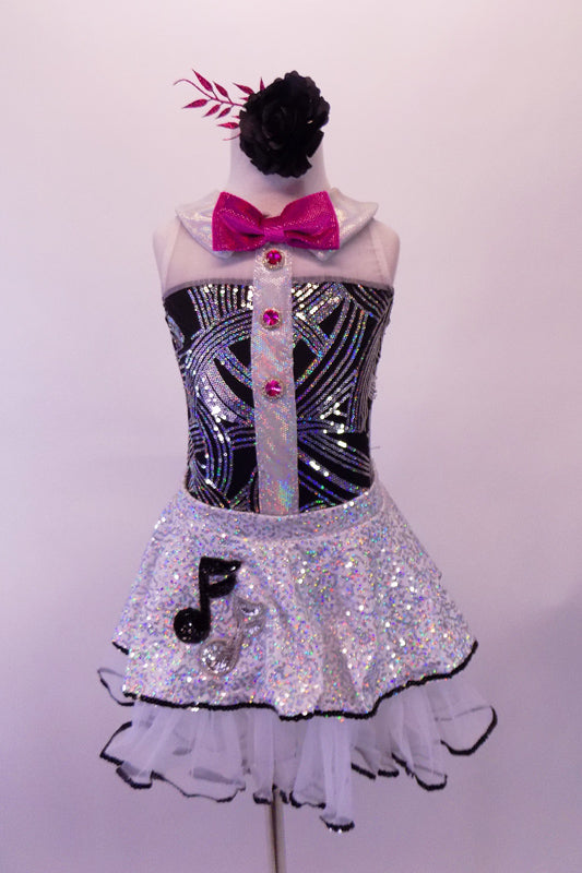 Music-themed leotard with black and silver swirled torso with white shoulders, collar & sheer back. There is a shiny vertical white stripe down the center of the torso with hot pink jewelled buttons that match the bow tie. The silver sequined skirt with white petticoat has black edge & musical note appliques. Front