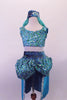 Turquoise 2-piece Arabian themed costumes has a fully sequined low-back, tank style half-top. The bottom is a brief with sequined bubble pouffe full bustle with long open front, knee length, turquoise taffeta skirt. The edge of the skirt is trimmed with silver lace that matches the silver & blue waistband & genie hat. Front
