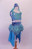 Turquoise 2-piece Arabian themed costumes has a fully sequined low-back, tank style half-top. The bottom is a brief with sequined bubble pouffe full bustle with long open front, knee length, turquoise taffeta skirt. The edge of the skirt is trimmed with silver lace that matches the silver & blue waistband & genie hat. Side