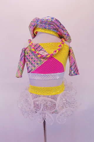 Two-piece pink yellow and silver paid patchwork half-top has ¾ cold shoulder sleeves with braided shoulder straps that extend into a necklace accent at the front. The bottom is a matching plaid patchwork brief with yellow waistband and white glittery curly hem, layered ruffle skirt. Comes with plaid tam hat. Front