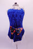 Three-piece costume has a gold half top and briefs which sit below a blue velvet brocade tunic. The tunic is a V-neck with white lace ruffle at the neckline and hip and floral bow accent at back. Comes with lace ruffled velvet gauntlets. Back