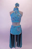 Two-piece turquoise costume is a halter neck half top with a lace-up corset back. The top is covered extensively with beautiful large 3-D floral appliques. The brief bottom has a wide waistband with floral appliques and an attached open front long teal skirt. Comes with a teal floral hair accessory. Front