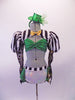 Money-themed 3-piece costume has a green sequined bra top with corset back. The bra sits beneath a black and white striped shrug jacket that has a gold bow tie. The striped pouffe sleeves have a sheer polka dot long sleeves.  The bottom is a white brief with striped bustle skirt with green accents & gold dollar symbol. Front