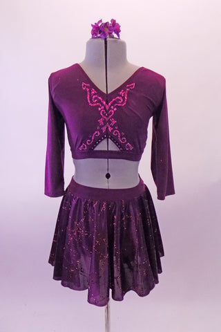 Two-piece purple costume has a long-sleeved haft top with V-front neck, low scoop back and glitter design front. The matching short chiffon circle skirt has angled glitter design and attached brief. Comes with a floral hair accessory. Front