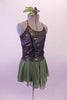 Olive-green based costume has black and pewter lace overlay top with princess seams and crystal covered cross back straps. Beneath the lace is an olive metallic base. The attached olive chiffon skirt has an attached brief. Comes with a floral hair accessory. Side