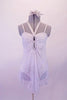 White leotard dress has white sheer, crystalled silver floral print with pinched double looped front and crystal covered straps.  A wide V band that extends from the front is covered with crystals that attach at the neck. Comes with a white floral hair accessory. From