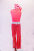 Coral crystalled tank top with scoop back is accompanied by coral shimmery pants. A white leatherette laser cut lace belt and matching wristbands accent the outfit. Comes with matching hair scarf. Front