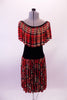 Red based tartan knee-length dress has black lycra torso and a wide ruffle that circles entire shoulder and collar. Comes with a floral hair accessory. Front