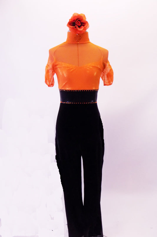 Orange and black unitard has a sheer orange mesh top with a built-in camisole beneath. The attached black velvet pants have a wide high-waist belt lined with orange crystals. The high collar also has a crystal design. Comes with an orange floral hair accessory. Front