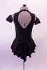 Black leotard dress has a short flowy peplum skirt that attaches in a low front/back princess cut waistline. The back is an open keyhole. Comes with ruffled armband accessory. Back