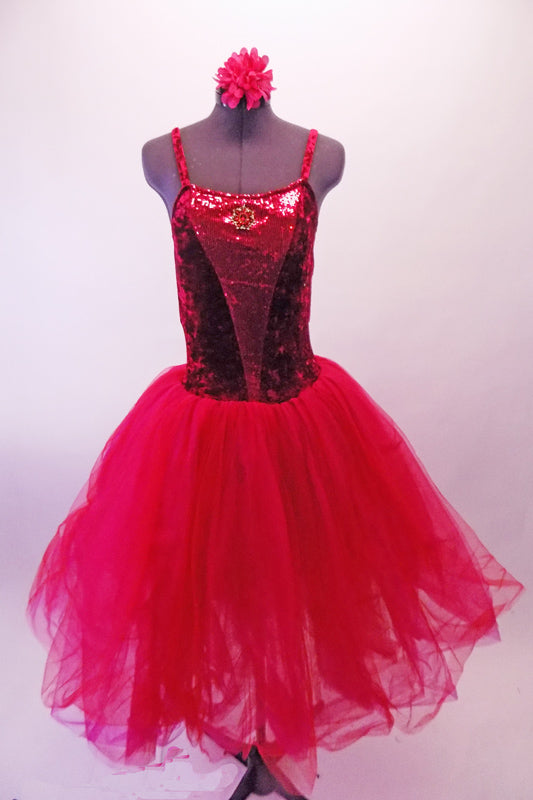 Crimson red romantic tutu has long tulle skirt with a crushed velvet bodice. The front center of the torso is red sequin with a large red jewel brooch accent. The back has a nude panel with faux corset ties. Comes with a floral hair accessory. Front