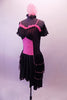 Saloon themed dress has a pink torso overlain by sheer black stripes at bust, sides and back. The knee-length skirt has triple-layered black peplum bustle. Pink ruffles accent the sweetheart neckline. Comes with black sheer striped pull-on sleeves and feathered hair accessory. Side
