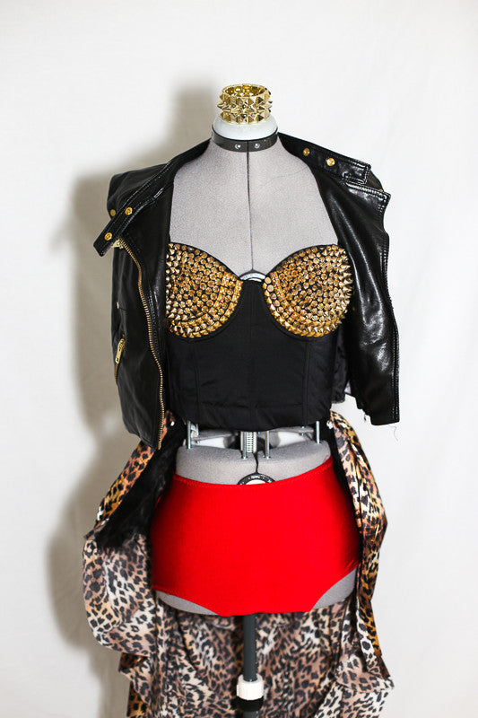 Black corset with gold spikes on bra accompanies red panty, leather, zippered vest and a ruched, bustled, leopard skirt with crinoline booty, front