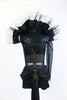 Black sequined bodice with single sleeve, adorned with silver and black chains and a large cameo. Leathery shorts with sash and removable large tulle collar, back