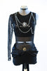 Black sequined bodice with single sleeve, adorned with silver and black chains and a large cameo. Leathery shorts with sash, front