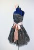 Dark grey dress with pewter lace overlay, has large pink sash and flower headpiece side