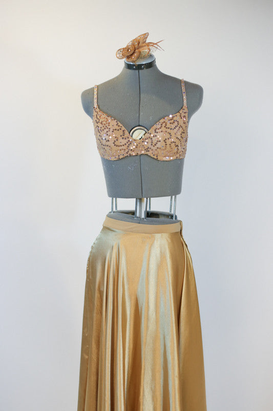 Gold shiny spandex brief, gold sequined bra and long flowing, ankle length, gold wrap skirt.skirt. with a gold hairpiece, front