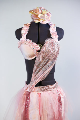 Pale pink bra has halter collar with pink satin ruffles  Has a crystal/beaded silk cascading to right hip Skirt has strips of varying pink delicate fabrics. Front zoom