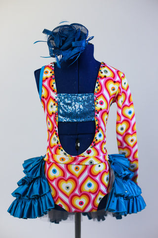 Open front, leotard has rainbow heart pattern& sequined bandeau top. Has attached ruffled teal open-front skirt covered with crystals and a matching hair piece. Front zoom