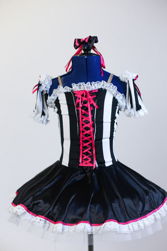 White platter tutu, has black satin overlay & pink piping. Striped  bodice has pink ribbon corset detail &matching shoulder poufs &matching hair accessory.Front zoom