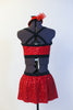Red sequined bra top has black edging, criss-cross straps and a matching skirt with attacked black shorts. Comes with mini red jazz hat accessory. Back