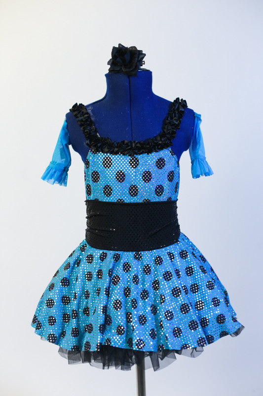 Blue glitter dress has black polk-a-dots & black gathered waistband. Dress has layered black petticoat skirt, blue gauntlets & black flower hair accessory. Front