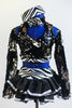 Black sequined top has long sleeves, high neck with zebra band and &bow. Open back has corset ties & is complimented by a ruffled black skirt & zebra pill hat. Front zoomed